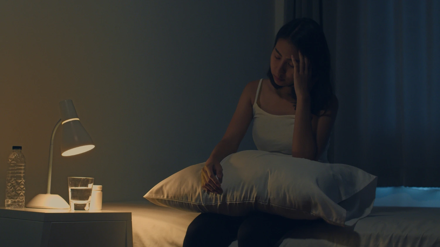 Roberto Reflexoterapeuta | HOME mulher sentada em sua cama à noite sofrendo com insônia
